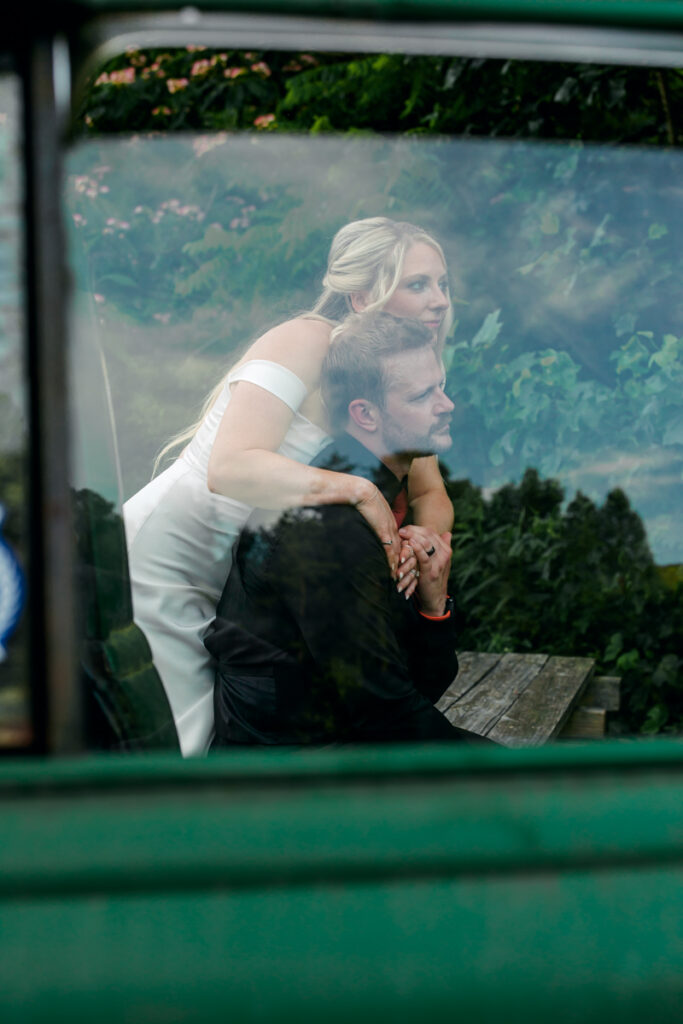 Newlyweds seen through the window of a green vintage truck