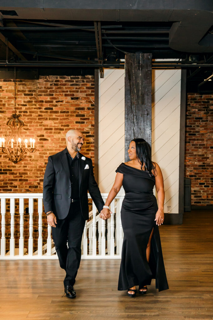 Couple walking hand in hand, gazing at each other with smiles