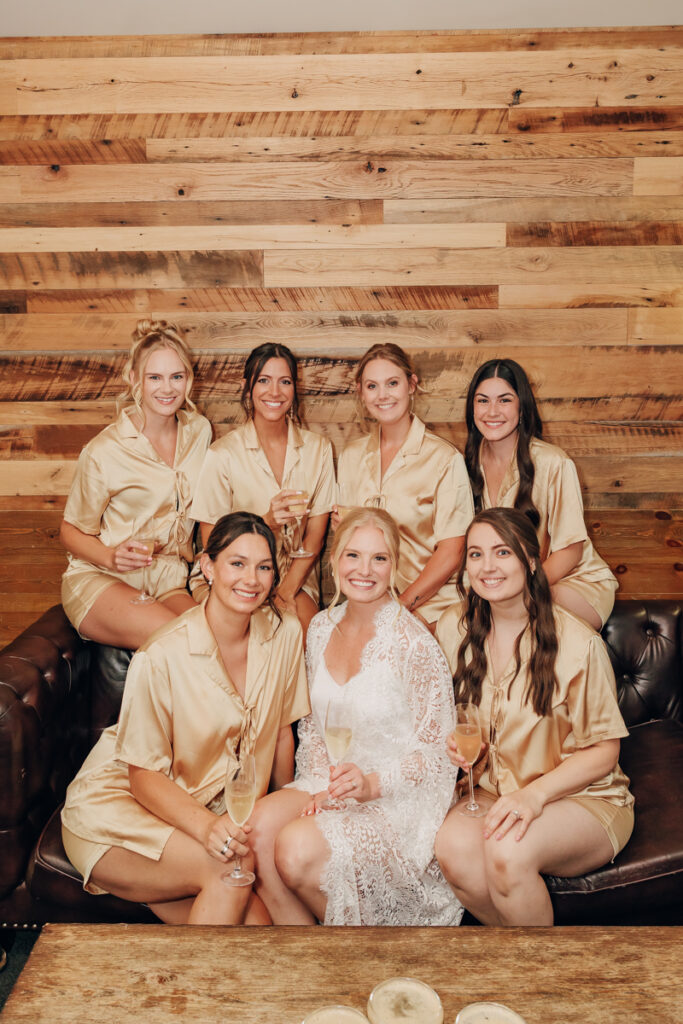 Bride with her bridesmaids in pjs and holding champagne