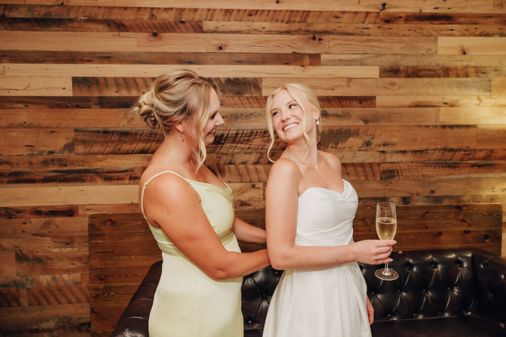 Bride getting zipped into her wedding dress