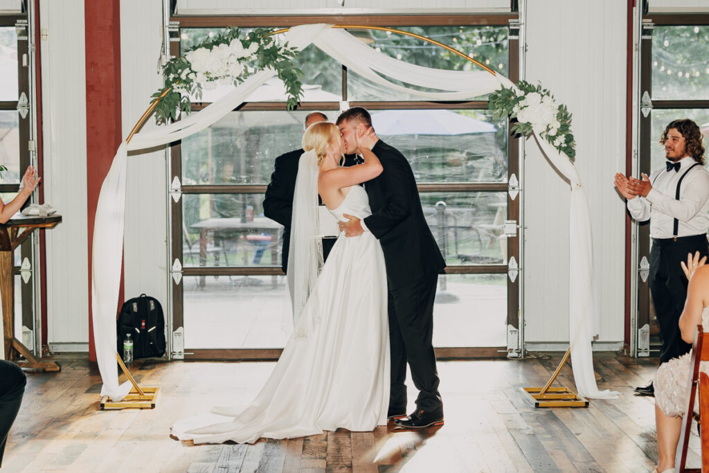 Bride and groom share their first kiss during their ceremony