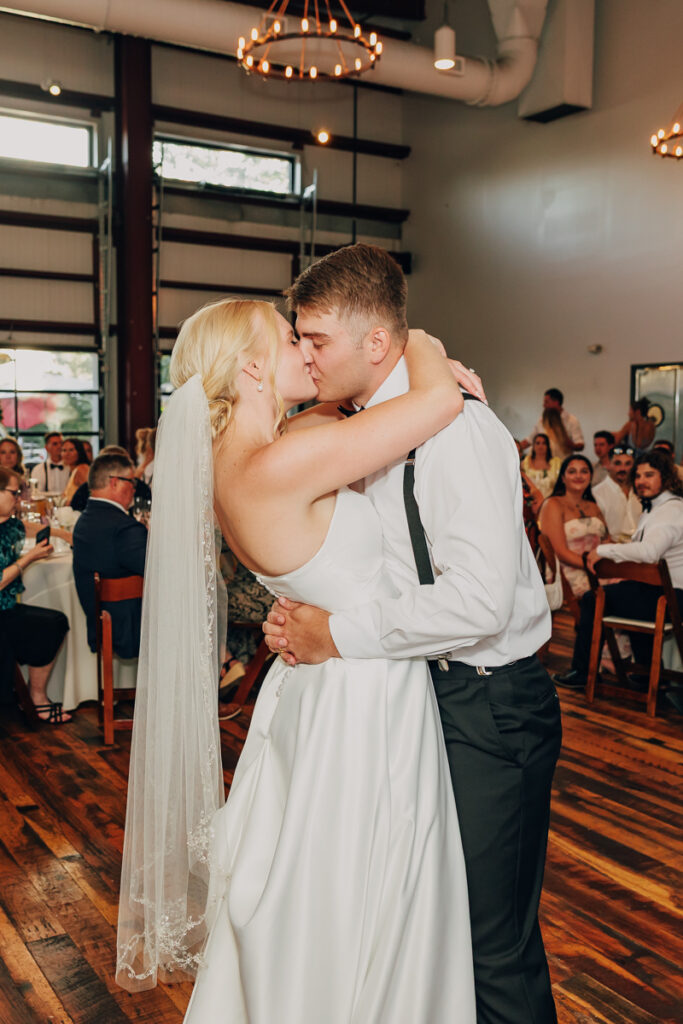 Bride and groom share a kiss at the end of their first dance