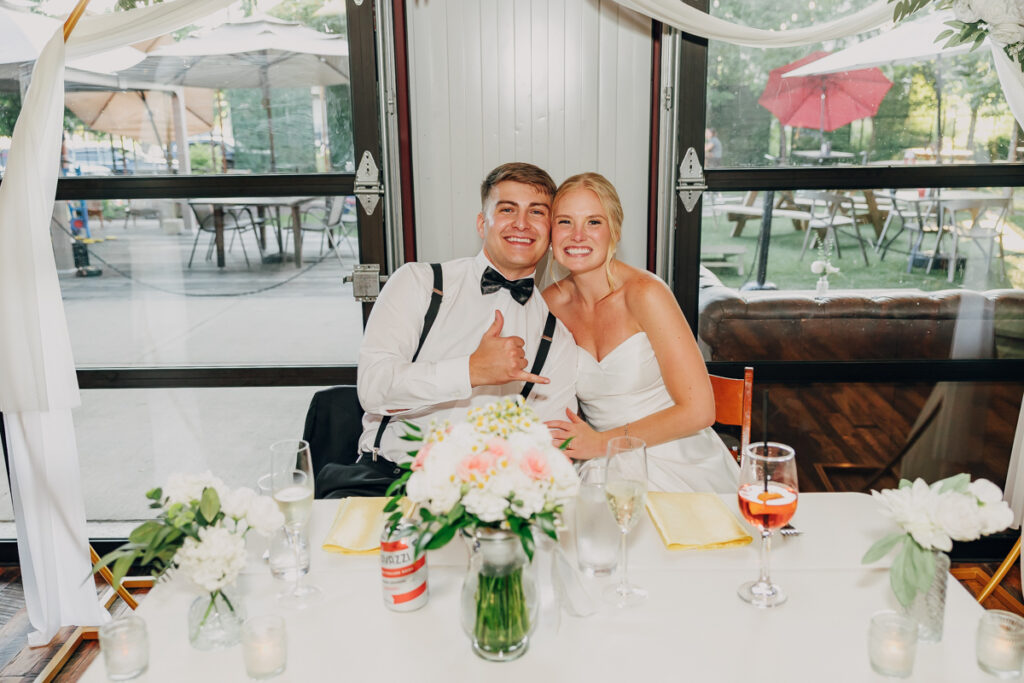 Bride and groom sitting at their reception table at The Reserve at Fat Bottom Brewery