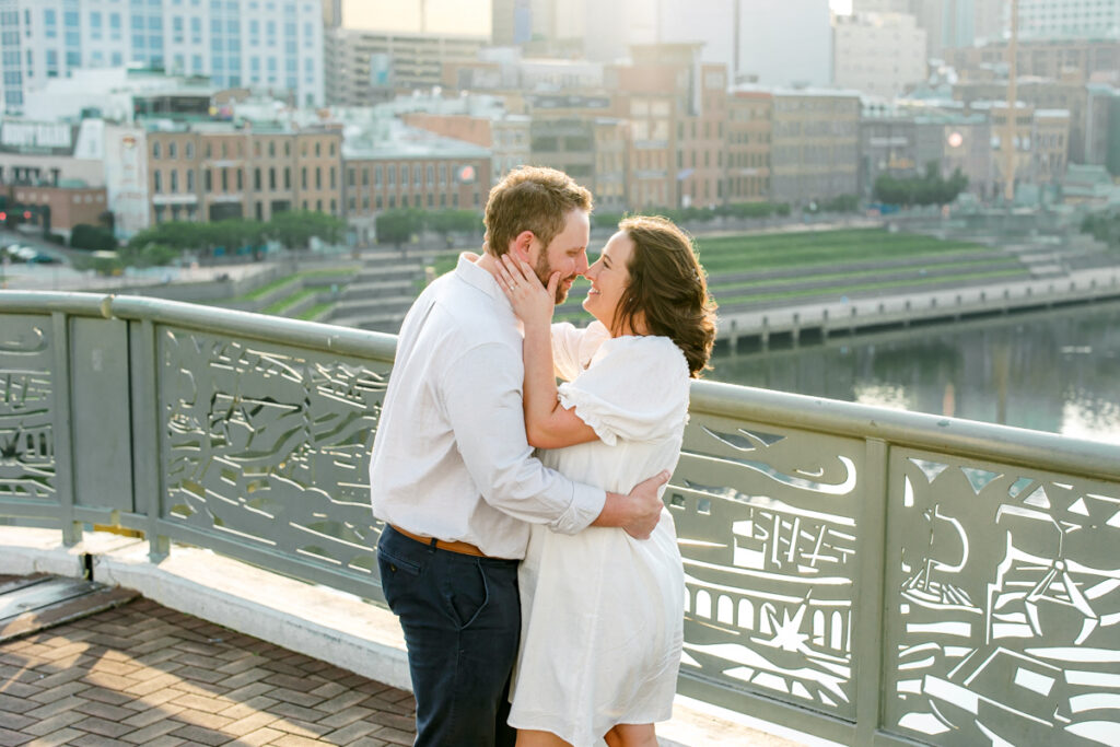 Engaged couple gazing into each other’s eyes on the John Seigenthaler Pedestrian Bridge in Nashville, TN