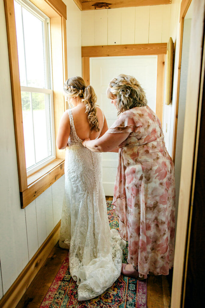 Bride's mom fastening her wedding dress at Allenbrooke Farms wedding