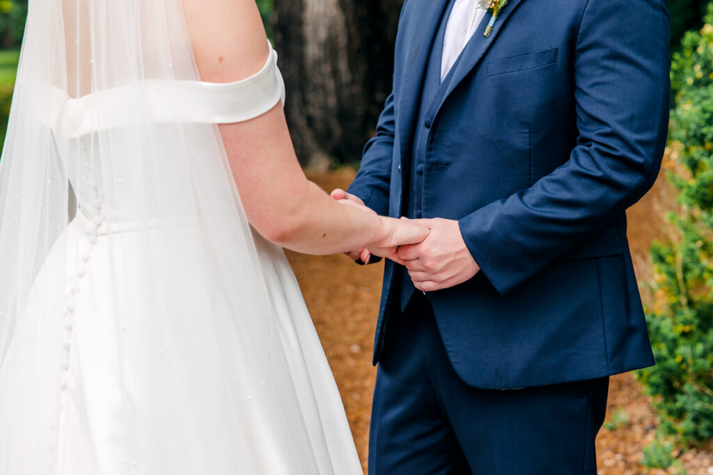 Close-up of bride and groom holding hands
