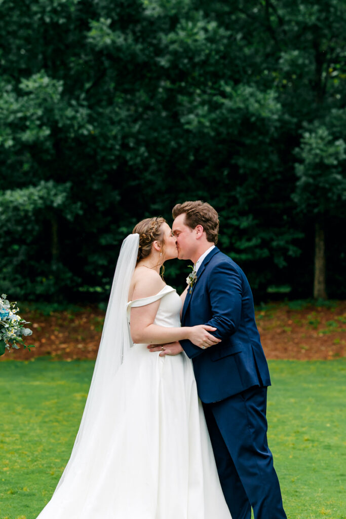 Bride and groom share their first kiss during their outdoor wedding ceremony at Homestead Manor
