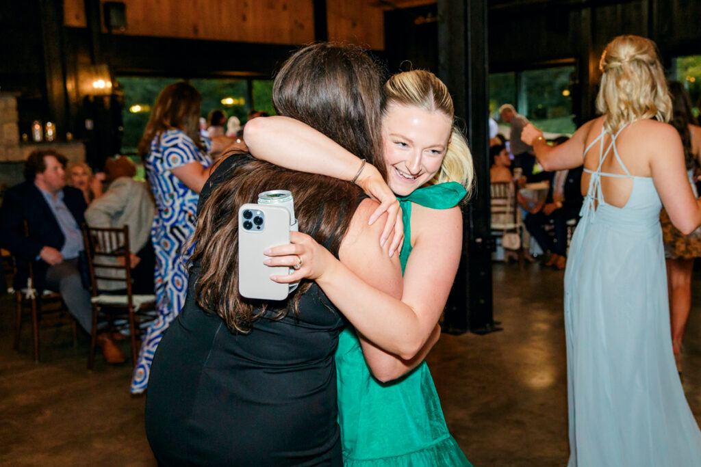 Wedding guests sharing a hug during wedding reception at Homestead Manor