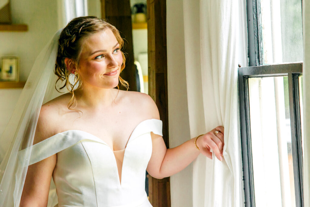 Bride gazing out the window of the bridal suite at Homestead Manor