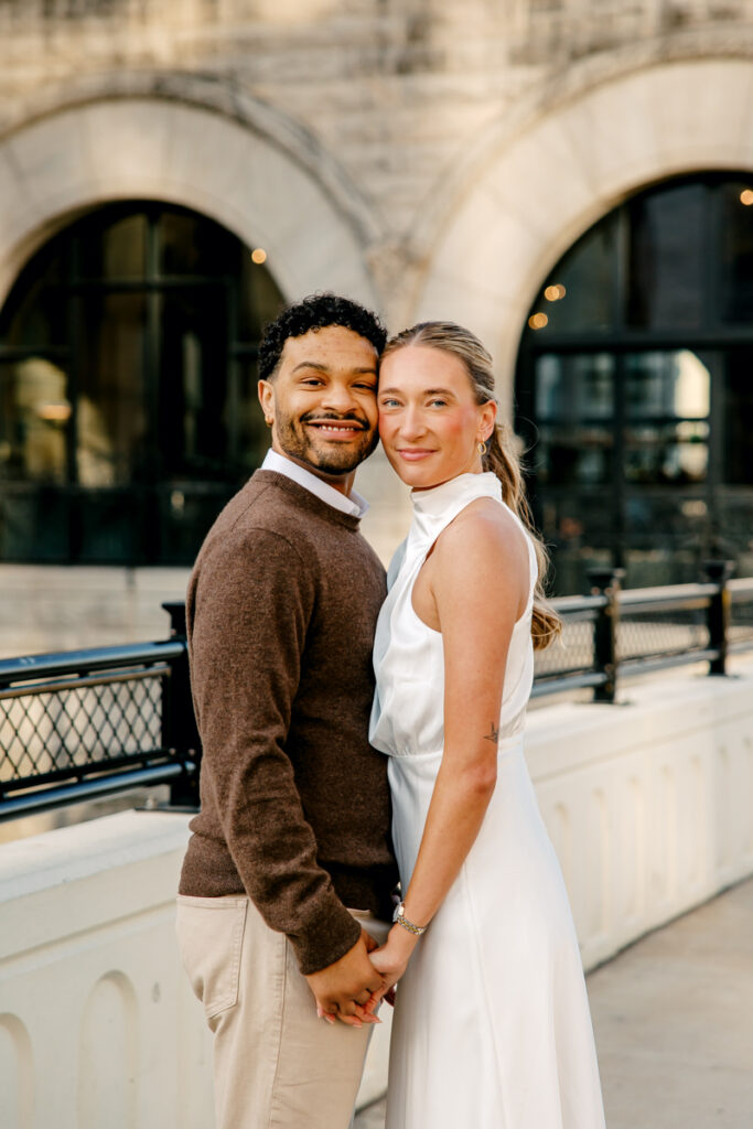 Couple standing cheek to cheek and smiling during their Union Station engagement session in Nashville