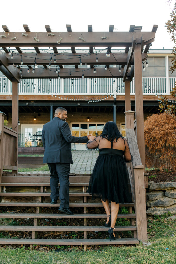 Man helping his fiancée up the stairs at Lighthouse on the Lake.