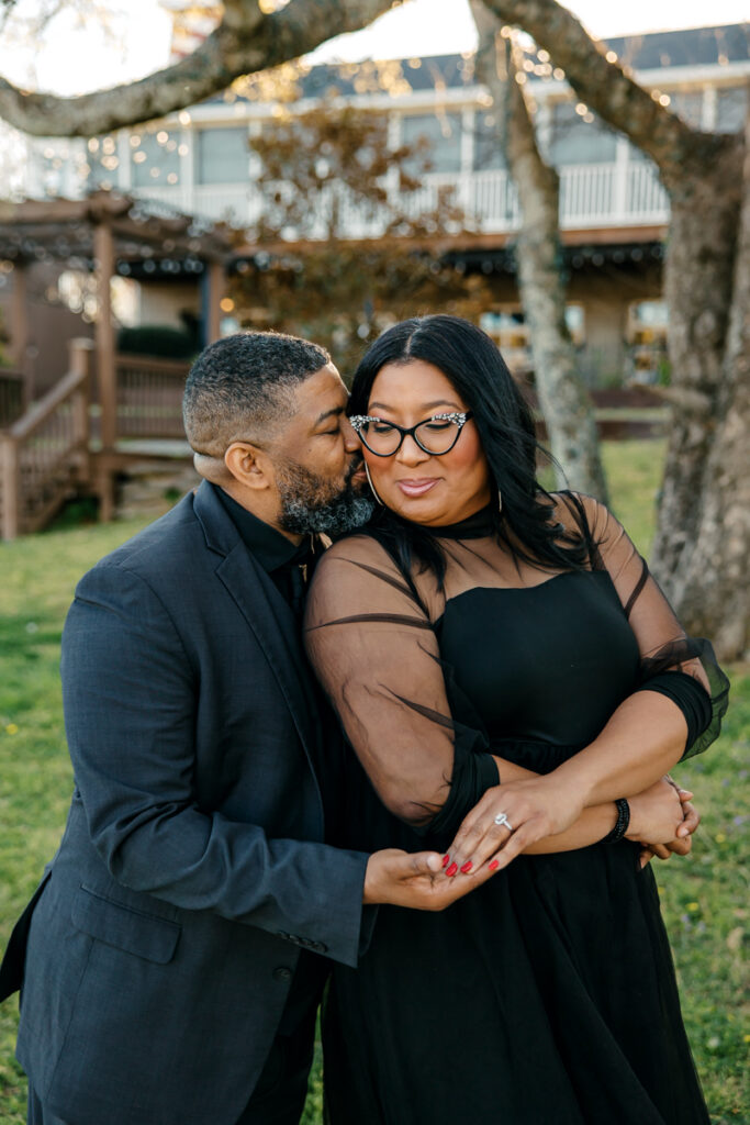 Man kissing woman on the cheek during their engagement photos in Hendersonville, TN