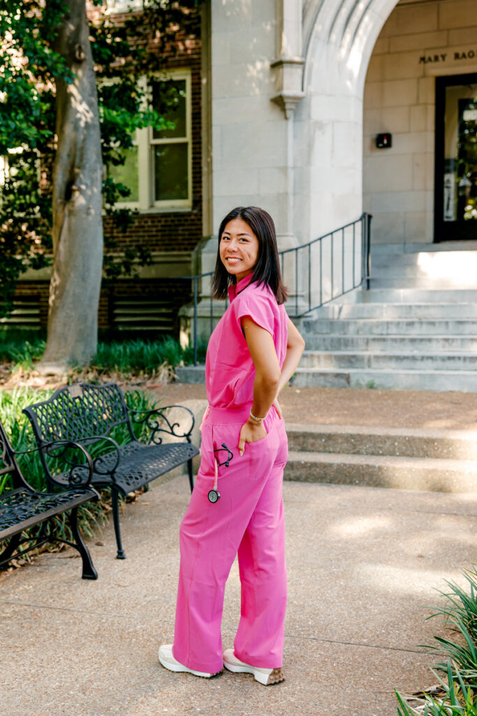 Nursing graduate posing outside Vanderbilt University School of Nursing with a stethoscope in her pocket