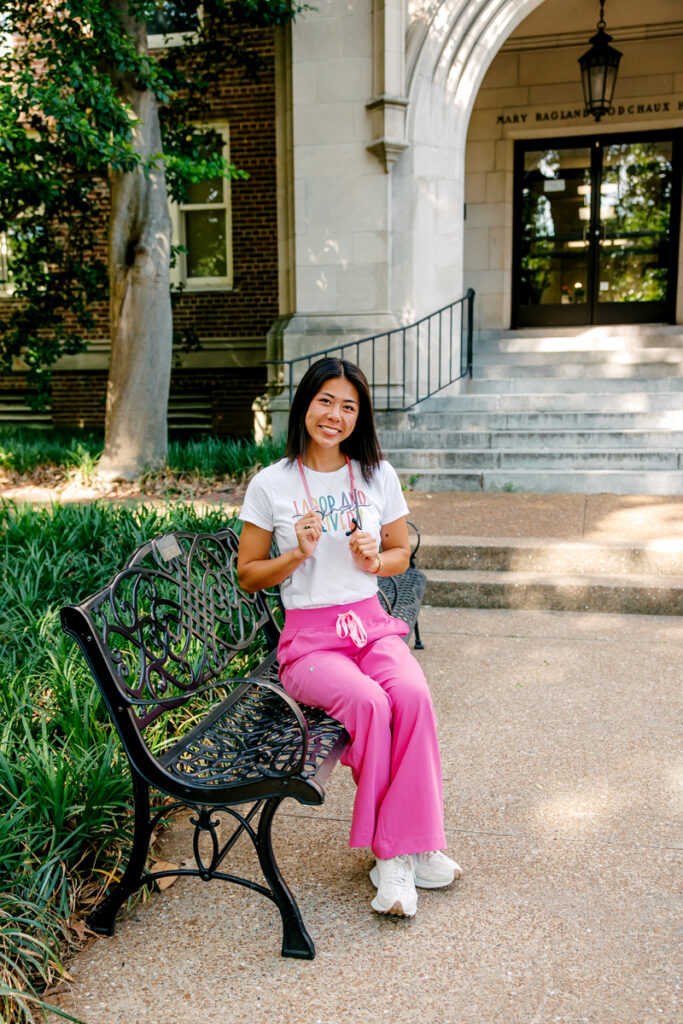 Vanderbilt graduate sitting on bench with stethoscope around neck during Nashville graduation portrait session