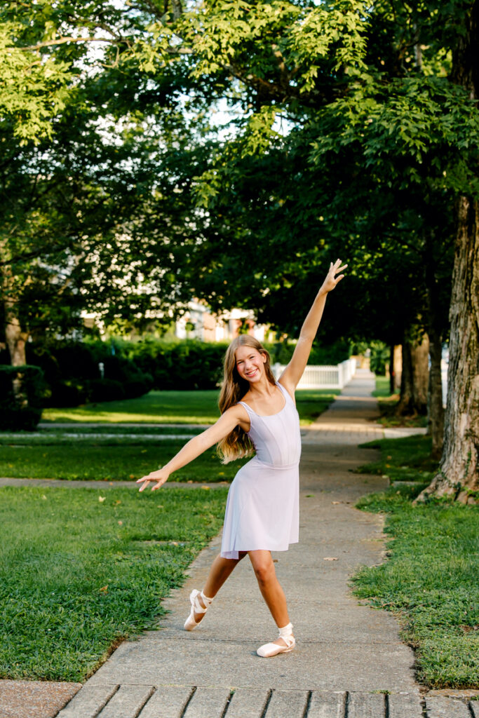 Ballet dancer standing on a sidewalk in Franklin, Tennessee, in a tendu derrière position