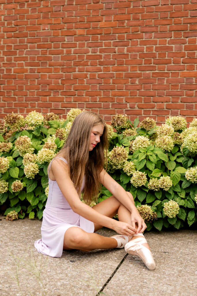 Ballet dancer tying her pointe shoe ribbons in Franklin, Tennessee